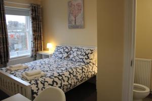 Un pequeño dormitorio con una cama con toallas. en Station Rooms, en Londonderry County Borough