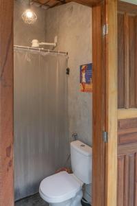 a bathroom with a toilet and a shower curtain at Glamping Coco Dendê - Algodões in Praia dos Algodões