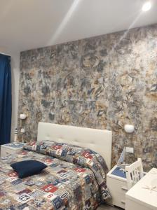 um quarto com uma cama e uma parede de pedra em B&B La Grotta em Nicolosi