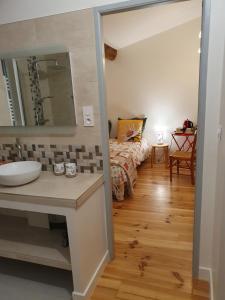 a bathroom with a sink and a bed in a room at Chez Danièle et Jean-Pierre in Saint-Julien