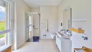 Collombey的住宿－Alp Art Hotel，带淋浴和盥洗盆的白色浴室