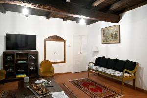 ein Wohnzimmer mit einem Sofa und einem TV in der Unterkunft Palazzo Granaroli in Bagnoregio