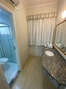 a bathroom with a sink and a toilet at Hotel Da Vinci in Serra Negra
