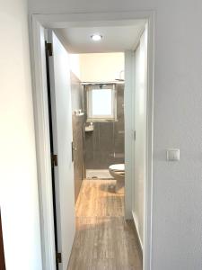 a bathroom with a toilet and a shower and a door at [MIRazul] Lovely condo 4 minutes walk to the beach in Costa da Caparica