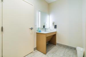 a bathroom with a sink and a mirror at Palace Inn Blue-IAH East in Humble +8 photos