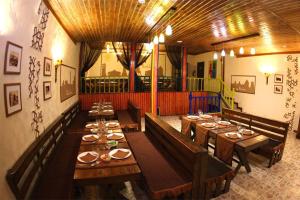 a large dining room with wooden tables and benches at DRIMIN by sunrise caravan - Family boutique guesthouse and hostel in Tashkent