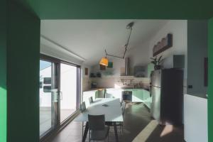 a kitchen with a white table and a refrigerator at Penthouse Belvedere City View with Private Parking in Rijeka