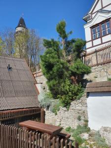 une maison avec une clôture et un arbre sur un mur dans l'établissement Štramberk V Kútě, à Štramberk