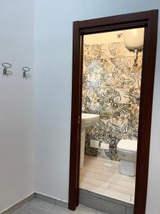 a bathroom with a toilet and a wall at House Caracciolo by Loveinthetravel in Naples +48 photos