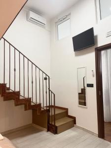 a staircase in a building with a tv on the wall at House Caracciolo in Naples