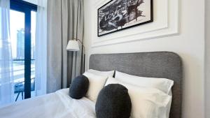 Un dormitorio con una cama con almohadas blancas y una ventana en Business Bay - Near Metro Station - 1 Bedroom Apartments - Zada Tower - Keyrock HH en Dubái