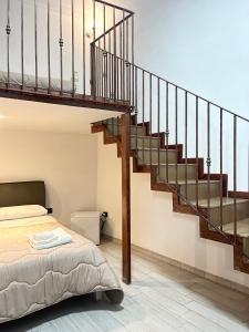 a bedroom with a bed and a staircase at House Caracciolo in Naples