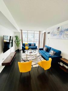a living room with blue couches and yellow chairs at Royal Suite in Toronto