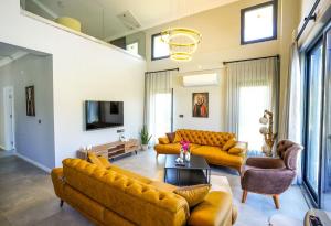 Dalyan Villa Petra في داليان: غرفة معيشة مع كنبتين وتلفزيون