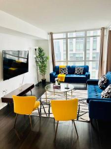 a living room with a blue couch and yellow chairs at Royal Suite in Toronto