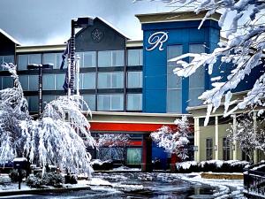 a building with snow covered trees in front of it at The Ramsey Hotel and Convention Center in Pigeon Forge