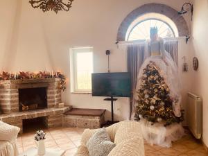 sala de estar con TV y árbol de Navidad en La Cascina Scalera per il tuo relax con piscina sauna ed Idromassaggio, en Castel Campagnano