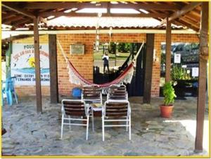 un grupo de sillas y una hamaca en el patio en Pousada Solar das Andorinhas en Fernando de Noronha