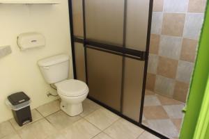 ein Bad mit WC und Glastür in der Unterkunft Cool & Calm Hotel in Manzanillo