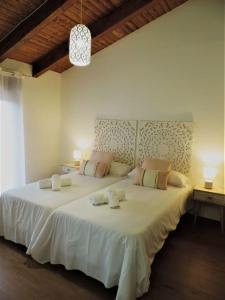 a bedroom with a large white bed with two pillows at Casa Rural: La Tarara 