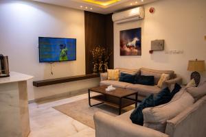 a living room with two couches and a flat screen tv at Tara One Apartment By Alin in Riyadh
