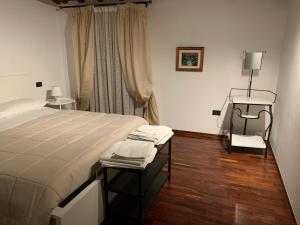 een slaapkamer met een bed, een stoel en een raam bij innvicolo in Santarcangelo di Romagna
