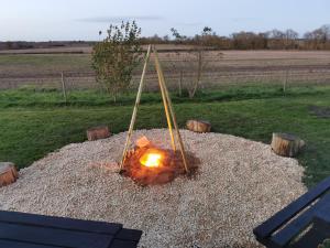 a fire pit in a pile of gravel in a field at Courtyard Hot Tub Dome Lincoln - Heated, Projector Firepit in Lincoln