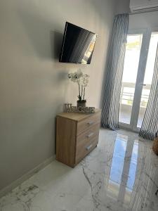 sala de estar con vestidor y TV en la parte superior en Eleni’s Mountainview Central Studio by the Sea en Loutraki