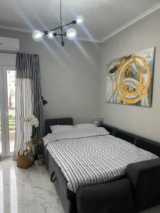 a bedroom with a bed and a painting on the wall at Eleni’s Mountainview Central Studio by the Sea in Loutraki