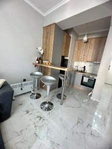 a kitchen with marble floors and a counter with stools at Eleni’s Mountainview Central Studio by the Sea in Loutraki