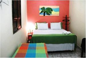 Dormitorio colorido con cama y pared colorida en Pousada Solar das Andorinhas, en Fernando de Noronha
