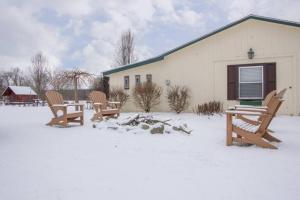 un grupo de sillas en la nieve frente a un edificio en 30 acre horse ranch with Bunk House, 