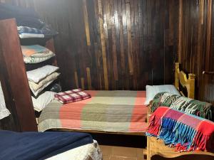 a room with a bed and a pile of blankets at Miguel Pereira, Casa Na Serra, RJ in Miguel Pereira