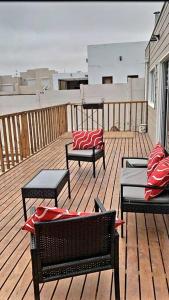 a deck with chairs and tables on a balcony at Cómodo, tranquilo y acogedor. in Caldera