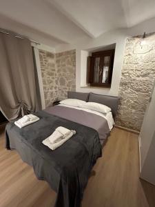 a bedroom with a bed with two towels on it at Pietrasuite Santa Brigida in Roccaraso