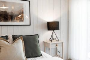 a bedroom with a bed and a lamp on a table at Luxurious & Modern Tremblant Loft Pool&Spa Access in Mont-Tremblant