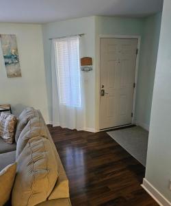a living room with a couch in front of a door at Nice 2 Bedroom 1 Bath Condo Across From Broadway in Myrtle Beach