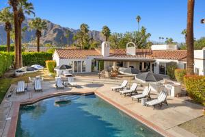 uma casa com uma piscina com espreguiçadeiras e uma casa em Ciao Bella Estates em Palm Springs
