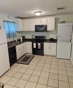 a kitchen with white cabinets and black appliances at Nice 2 Bedroom 1 Bath Condo Across From Broadway in Myrtle Beach