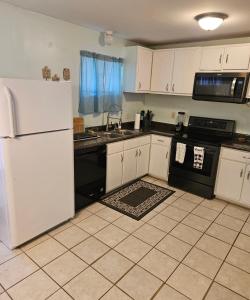 a kitchen with white cabinets and black appliances at Nice 2 Bedroom 1 Bath Condo Across From Broadway in Myrtle Beach