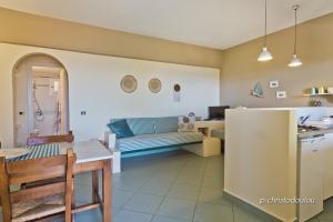 a kitchen and a living room with a couch at Rigò Apartments in Kyra Panagia