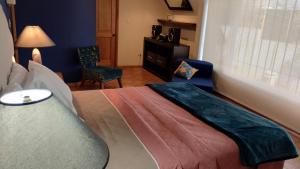 um quarto com uma cama, uma cadeira e uma janela em Amplia habitación Hacienda Santo Domingo em San Lucas Sacatepéquez