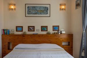 a bedroom with a bed with a wooden headboard at Cerasiello in Naples
