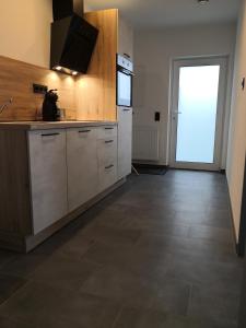 an empty kitchen with a refrigerator and a door at Apartment in Nonnweiler-Otzenhausen in Nonnweiler