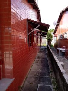 un bâtiment en briques rouges avec un banc à côté dans l'établissement CASA EM PORTO, à Porto de Galinhas