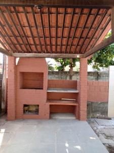 a brick shelter with a bench and a fire place at CASA EM PORTO in Porto De Galinhas