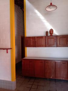 an empty kitchen with wooden cabinets and a yellow pole at CASA EM PORTO in Porto De Galinhas