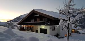 a building covered in snow with a tree at Molto Haus in Raggal