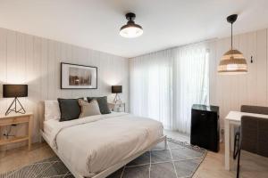 a bedroom with a large white bed in a room at Luxurious & Modern Tremblant Loft Pool&Spa Access in Mont-Tremblant +20 photos