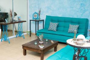 a living room with a blue couch and a table at CASA MINERVA MERIDA in Mérida